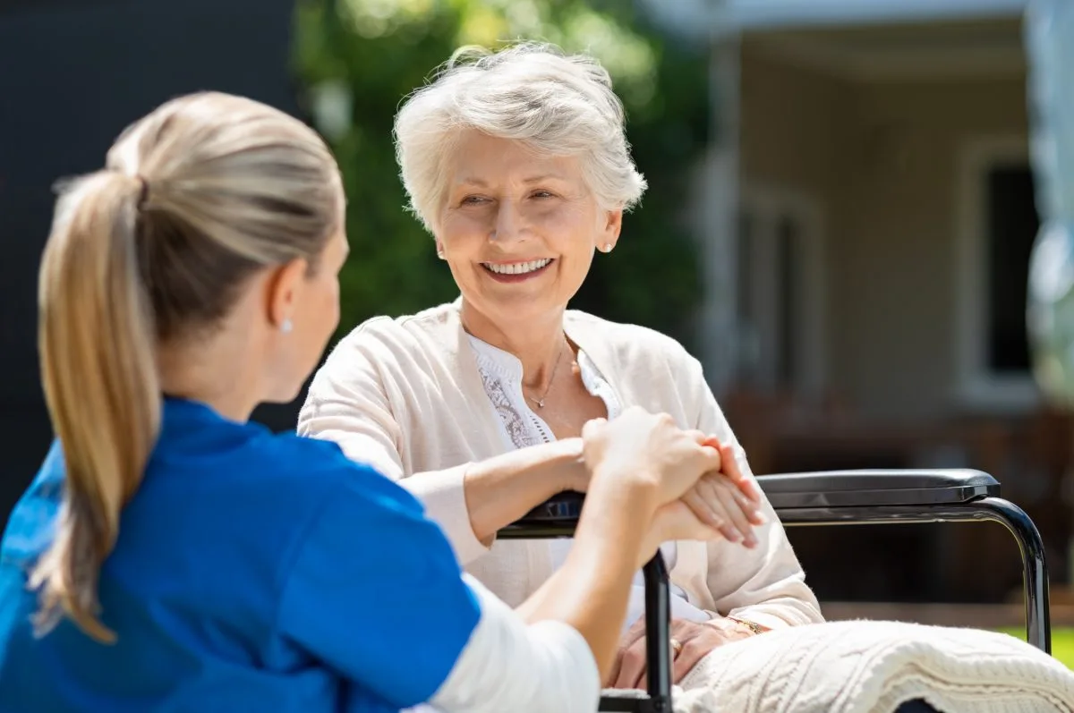 Nurse speaking with elderly patient in long-term care facility